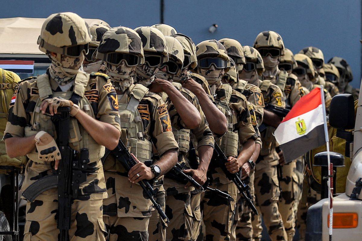 القوات الخاصة الجيش المصري القوات الخاصة الذين ينشرون أمام الحاجز الملموس الذي يمثل الحدود بين مصر وشريط غزة في رافح في شرق مقاطعة سيناء الشمالية في 20 أكتوبر 2023. (كيرولوس صلاح/AFP عبر غيتي الصور)