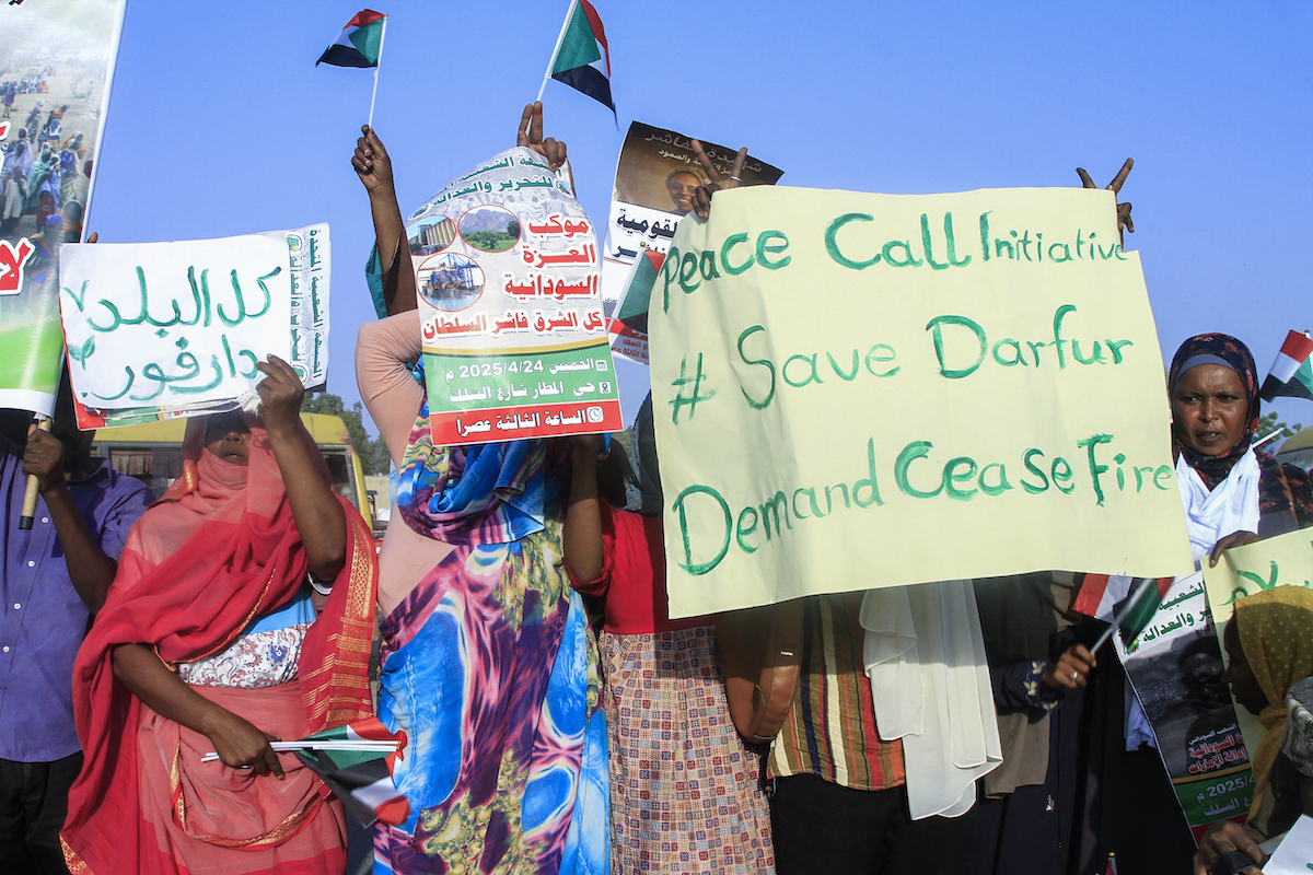 يرفع الناس الأعلام واللافتات الوطنية خلال مسيرة دعا إلى الجبهة الشعبية للسودان للتحرير والعدالة في بورت السودان في 24 أبريل 2025 ، لإنشاء الحصار التي تفرضها قوات الدعم السريع العسكري (RSF) في مدينة الفاشر والدعم التعبير لسكانها. (AFP/Getty Images)