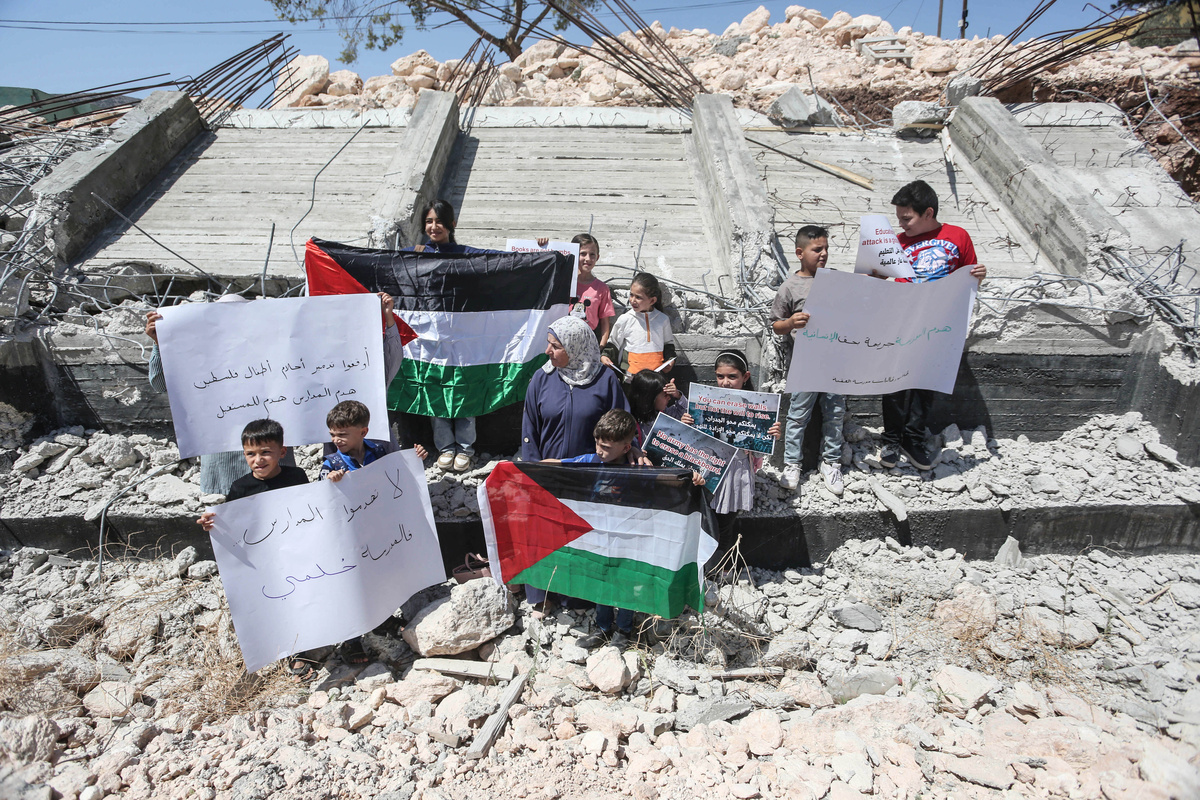يحتفظ الطلاب الفلسطينيون بأعلام ولوحات على أنابيبهم المدمرة في المدرسة المدمرة في المدرسة الأساسية التي تم تدميرها على هدمها من قبل القوات الإسرائيلية في قرية أقبة في وادي الأردن الشمالي ، شمال الضفة الغربية المحتلة. (تصوير صور Nasser Ishtayeh/SOPA/lightrocket عبر Getty Images)