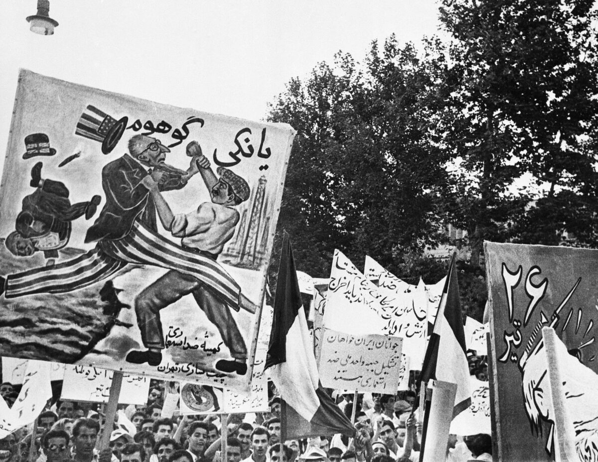 يحمل أعضاء حزب Tudeh (الشيوعي) في إيران لافتات التي تدين الولايات المتحدة وبريطانيا العظمى خلال مظاهرة قوية في ميدان برلمان طهران ، 21 يوليو 1953 (Bettmann/Getty Images)