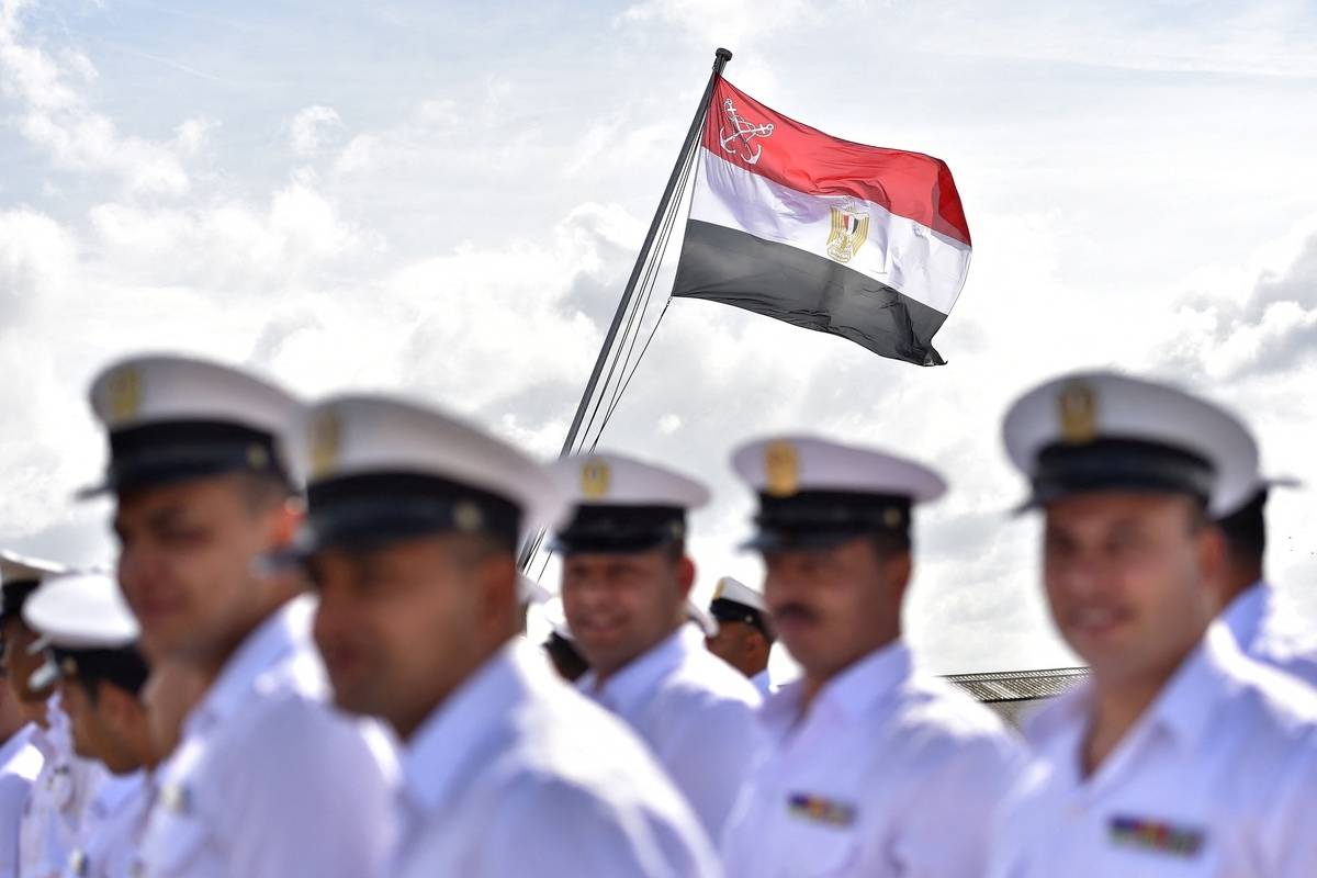يقف الجنود المصريون بينما يتم رفع العلم المصري على سفينة الرحلات البحرية العسكرية لـ BPC Anwar El Sadate خلال حفل العلم. (تصوير لويك الوادلة/AFP عبر Getty Images)
