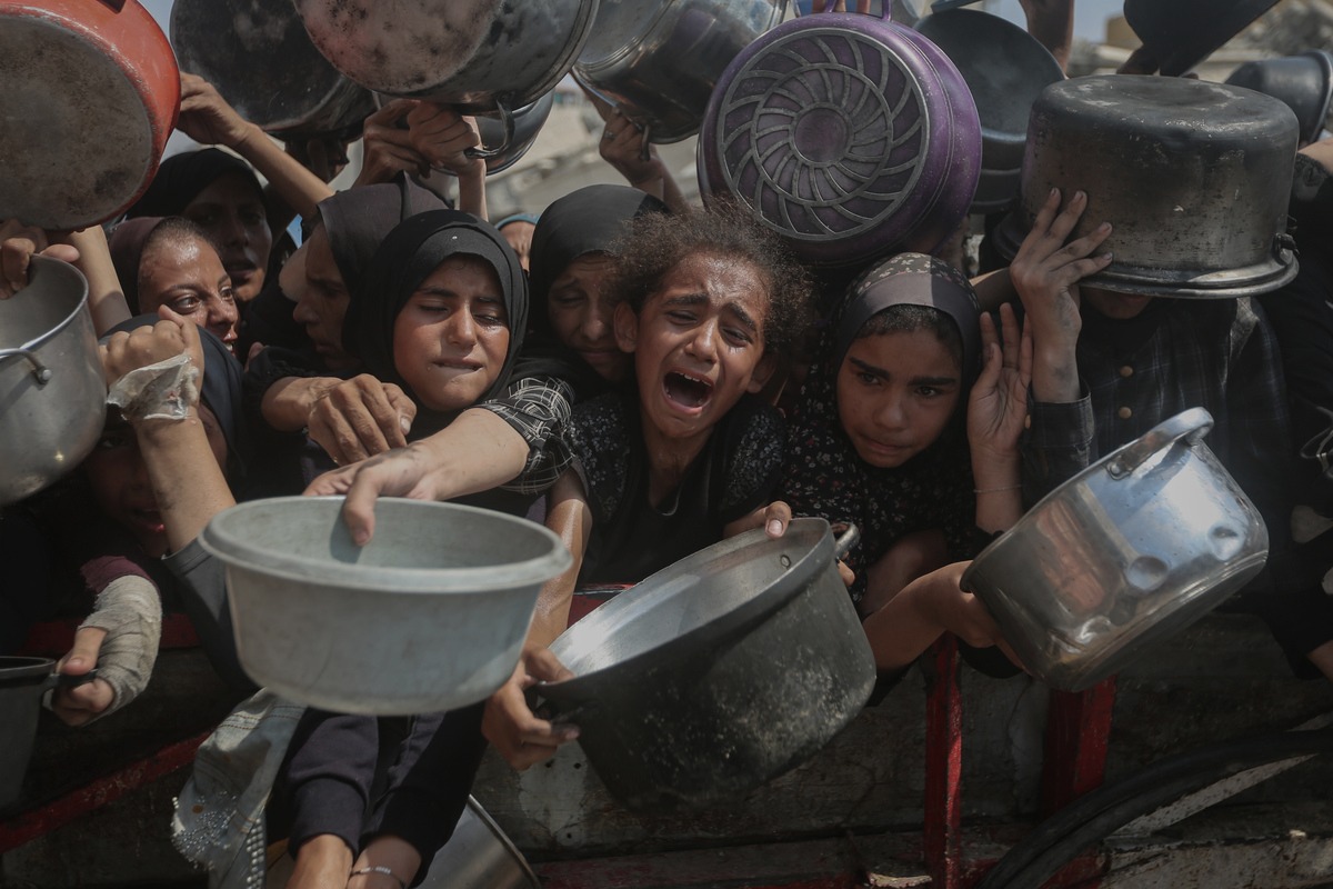 الجوعين الفلسطينيين بما في ذلك النساء والأطفال الذين يحملون الأواني ينتظرون لتلقي الطعام الموزعة من قبل منظمة خيرية حيث تواصل إسرائيل منع المساعدات الإنسانية من الوصول إلى قطاع غزة في 10 أغسطس 2025.