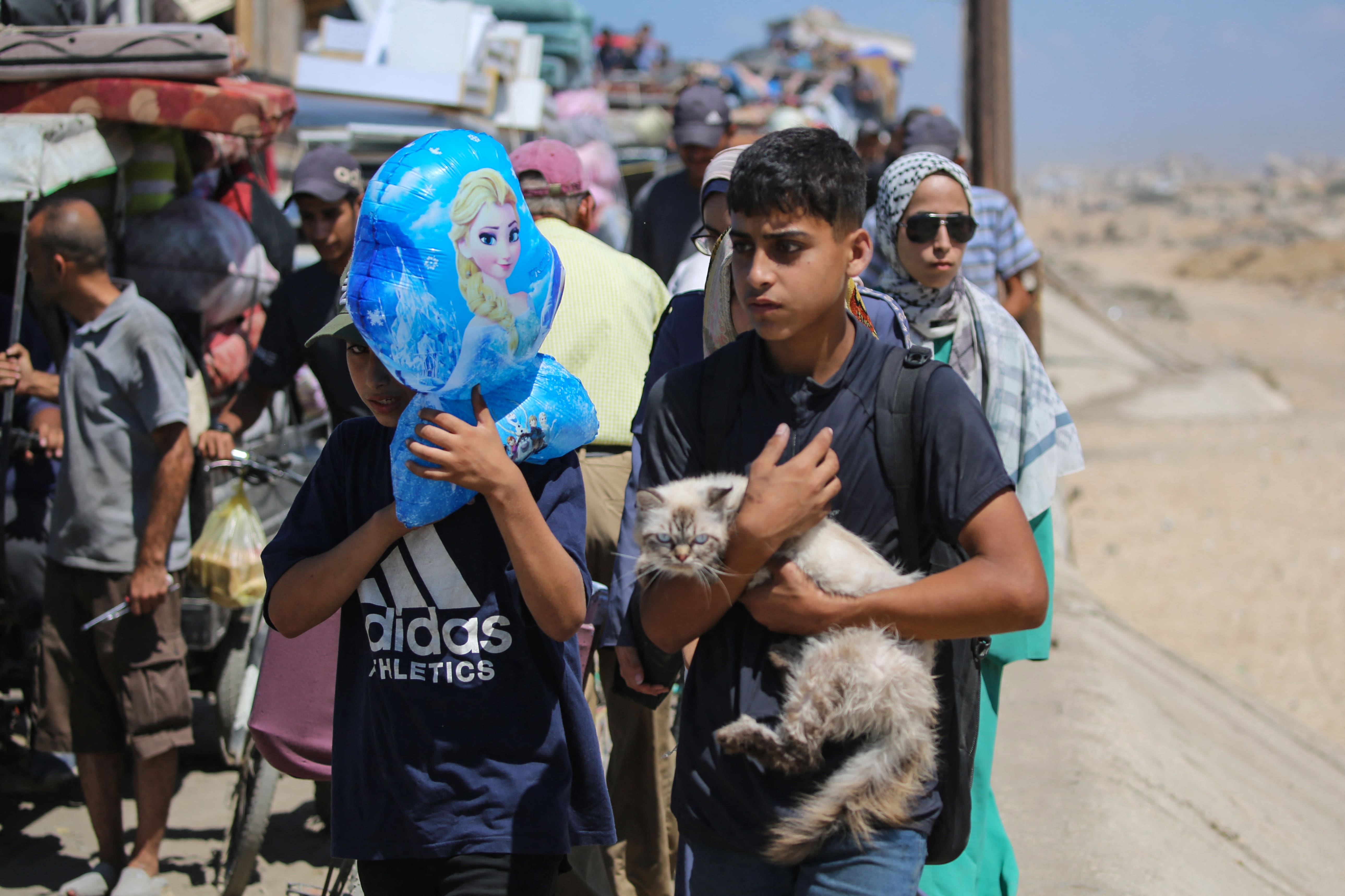 صبي فلسطيني يحمل قطة وسط نزوح من مدينة غزة نتيجة لأوامر الطرد الإسرائيلية (AFP/Eyad Baba)