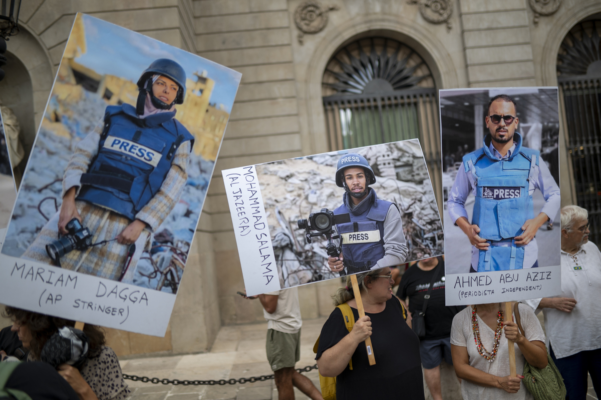 المئات من المتظاهرين الذين يحملون أعلامًا ، تجمع لافتات في Placa de Sant Jaume للاحتجاج على القتل الأخير للصحفيين الفلسطينيين في غزة خلال الهجمات الإسرائيلية في برشلونة ، إسبانيا في 27 أغسطس 2025.