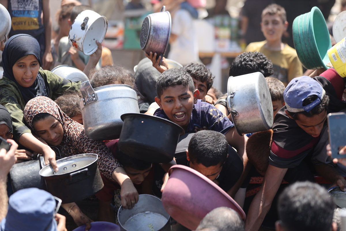 يتجمع الفلسطينيون ، بما في ذلك الأطفال ، الذين يكافحون للوصول إلى الطعام بسبب الحصار الإسرائيلي والهجمات المستمرة على قطاع غزة ، لتلقي وجبات ساخنة وزعتها المنظمة الخيرية في مدينة غزة ، غزة في 28 أغسطس 2025. (Khames Alrefi - Anadolu Agency)