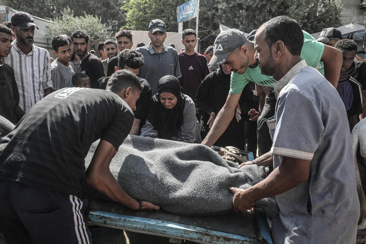 يحمل الفلسطينيون جثة ضحية لمستشفى الودا في معسكر اللاجئين في نوسيرا بعد أن فتحت القوات الإسرائيلية النار على المدنيين في انتظار المساعدات على طول ممر Netzarim في قطاع غزة في 2 سبتمبر 2025.