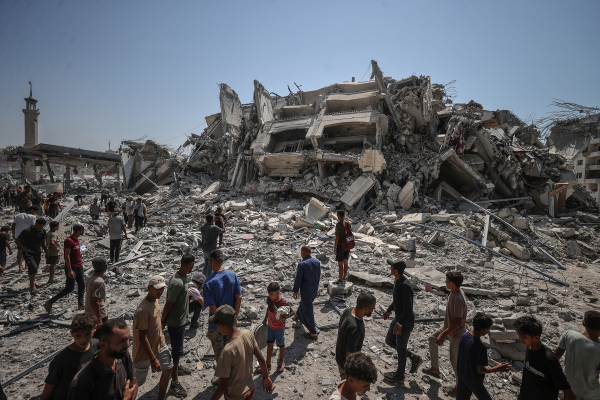 يتحرك الفلسطينيون في حالة من الذعر والدخان بعد برج موشتاها الذي يقع غرب مدينة غزة التي ضربتها غارات جوية إسرائيلية في غزة في 05 سبتمبر 2025 (علي جاد الله - وكالة Anadolu)