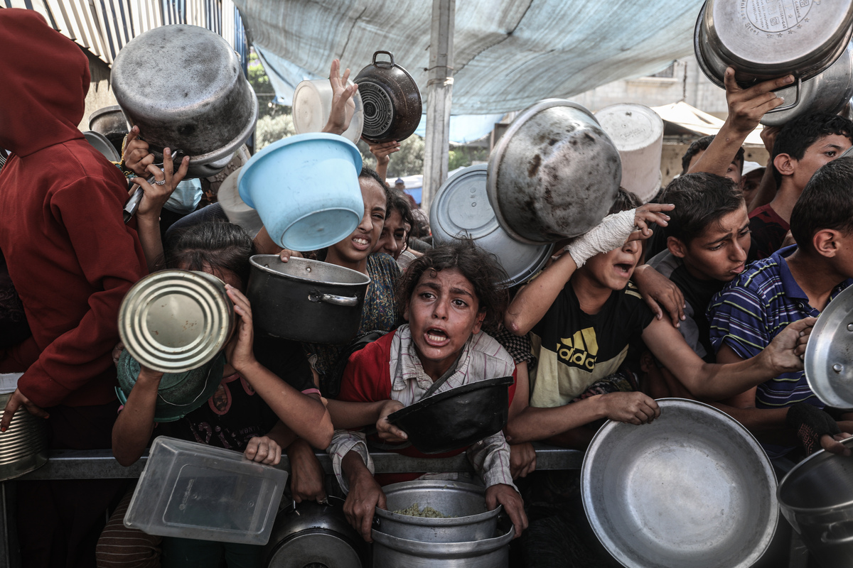 يجتمع الفلسطينيون ، بمن فيهم الأطفال ، أثناء توزيع الطعام في وسط مدينة غزة في 10 سبتمبر 2025.