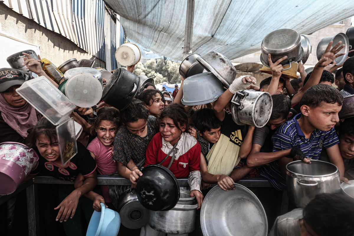 يجتمع الفلسطينيون ، بمن فيهم الأطفال ، أثناء توزيع الطعام في وسط مدينة غزة في 10 سبتمبر 2025.