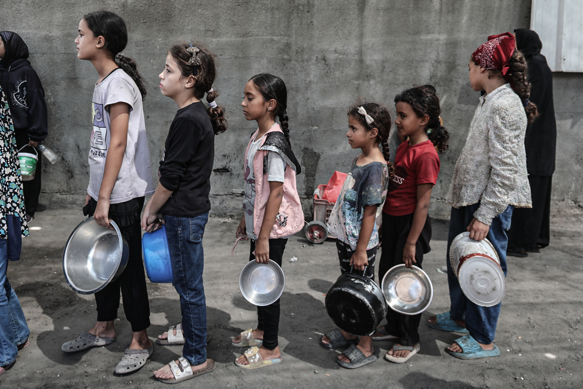 يجتمع الفلسطينيون ، بمن فيهم الأطفال ، أثناء توزيع الطعام في معسكر Nuseirat للاجئين في وسط غزة ، في 23 سبتمبر 2025.