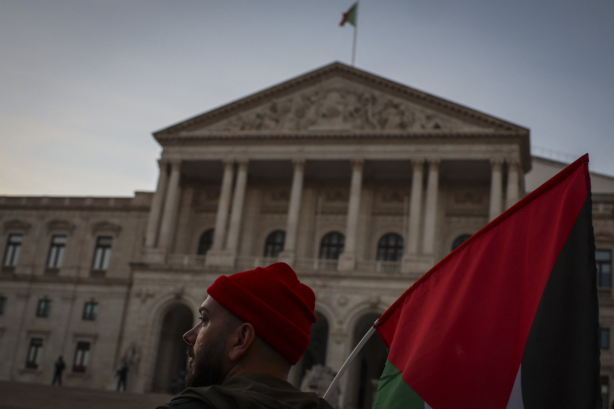 رجل يحمل علمًا فلسطينيًا أمام البرلمان البرتغالي أثناء مظاهرة للمطالبة بوقف إطلاق النار في الأراضي الفلسطينية ، في لشبونة في 18 نوفمبر 2023 (تصوير باتريشيا دي ميلو موريرا/فرو فرانس.