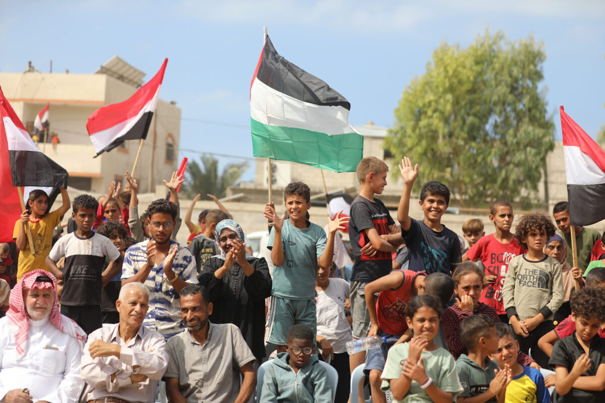 فلسطينيون، بينهم أطفال، متجمعون في مدينة دير البلح يحتفلون بعد إعلان اتفاق وقف إطلاق النار في غزة في 09 أكتوبر 2025 في خان يونس بغزة. (حسن جدي – وكالة الأناضول)