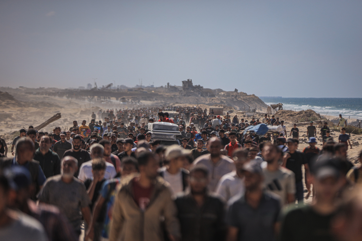 فلسطينيون يسيرون على طول شارع الرشيد، الطريق الساحلي الرئيسي الذي يربط جنوب ووسط غزة بالشمال، أثناء عودتهم إلى منازلهم بعد اتفاق وقف إطلاق النار الجديد بين إسرائيل وحركة حماس الفلسطينية في مدينة غزة، غزة، في 10 أكتوبر، 2025. (Hamza ZH Qraiqea-Anadolu Agency)