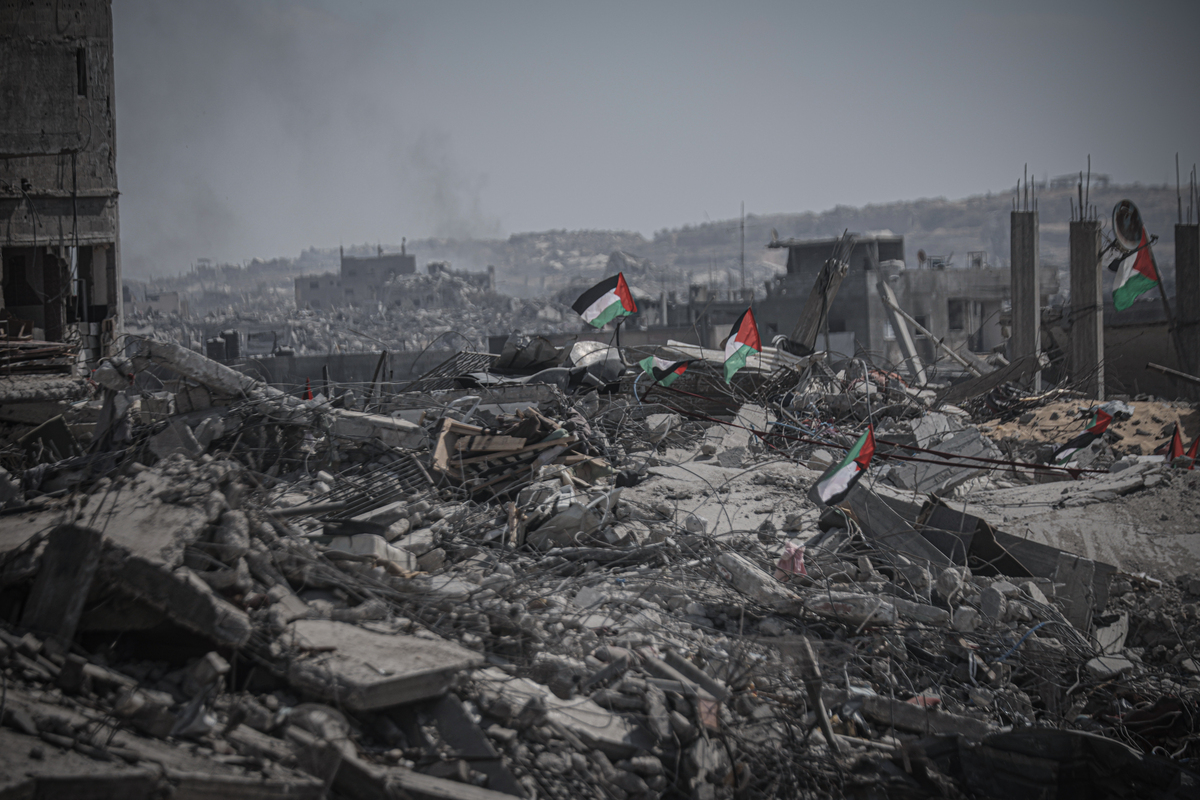 الأعلام الفلسطينية تظهر بين أنقاض المباني المدمرة مع استمرار السكان في العودة إلى شمال غزة بعد وقف إطلاق النار وانسحاب القوات الإسرائيلية في 13 أكتوبر، 2025. (أحمد جهاد إبراهيم العريني – وكالة الأناضول)