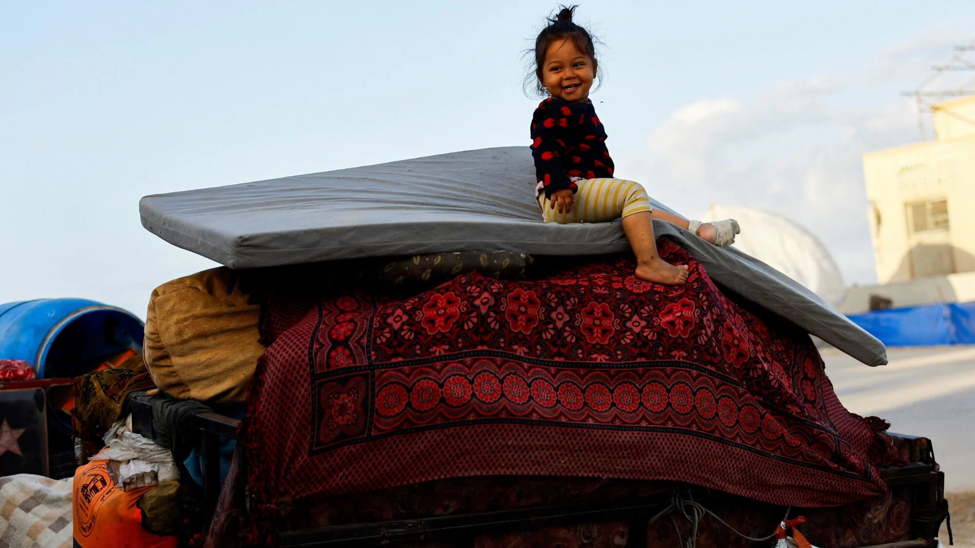 طفل يجلس فوق متعلقات في سيارة بينما يحاول الفلسطينيون العودة إلى الشمال، 10 أكتوبر 2025 (محمود عيسى/رويترز)